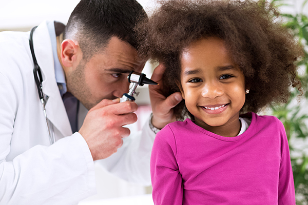 Doctor checking child's ears